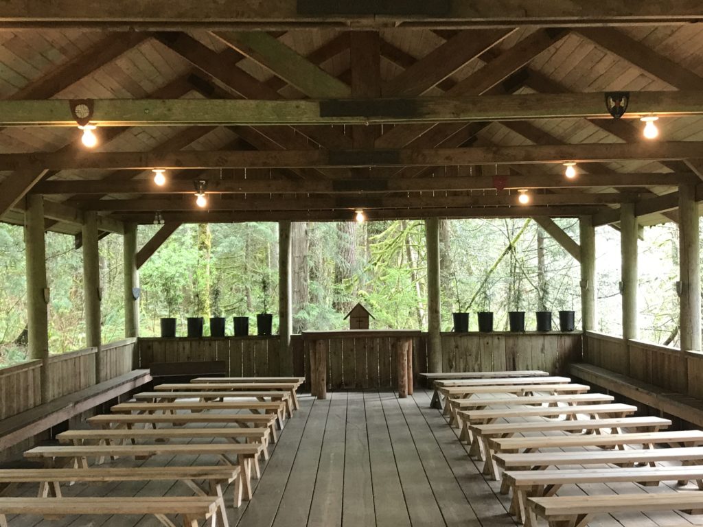 A shot of the inside of the outdoor open-air chapel. Benches are set up in rows.
