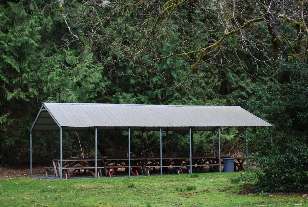A view of the Tin Roof, a small covered structure with picnic tables and benches