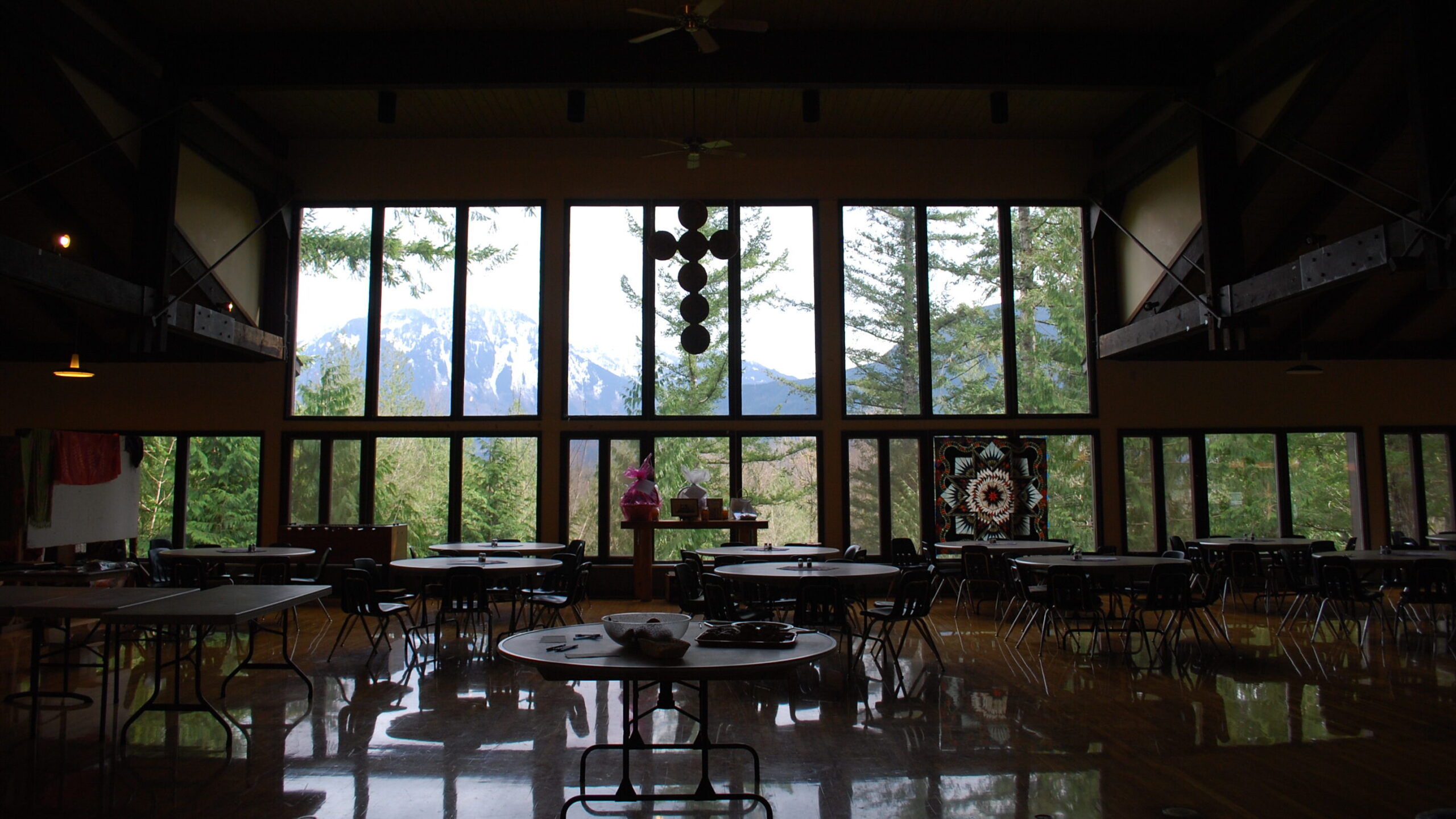 A contrasted shot of the dining hall, highlighting the mountain outside and the colorful quilt hanging in the window