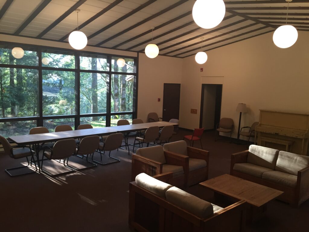 An inside shot of Paddock Lodge, which shows couches around a coffee table and other chairs and tables set up for a meeting