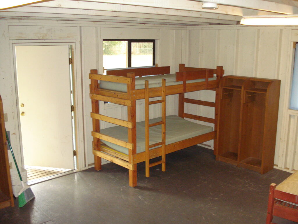 Inside view of a cabin, showing a bunk bed and storage space